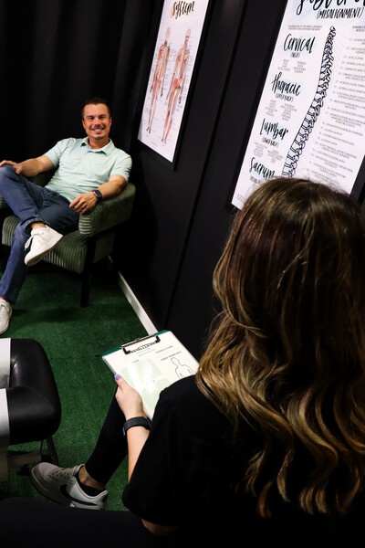 Dr. Taylor Hartman of Limitless Sports Chiropractic in Oak Point, TX, providing a professional consultation for a patient seeking sports injury relief near Aubrey and Little Elm.