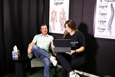 A patient scheduling a follow-up appointment at the Limitless Sports Chiropractic front desk in Oak Point, serving athletes from Little Elm and Aubrey.