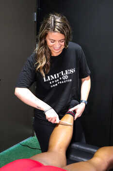 Graston Technique instrument being used on a patient's knee and quad to treat patellar tendinitis at Limitless Sports Chiropractic.