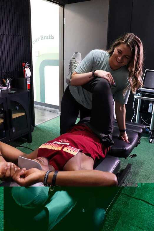Manual straight-leg hamstring stretch being performed on a patient at Limitless Sports Chiropractic, illustrating Active Release Technique treatment for hamstring tightness.