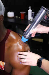 Shockwave therapy device being applied directly to a patient's shoulder to treat rotator cuff tendinopathy at Limitless Sports Chiropractic.