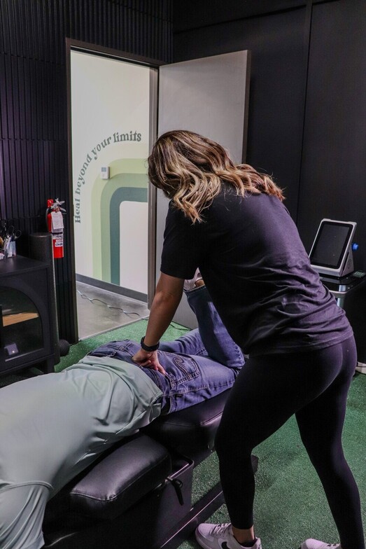 Chiropractor performing a hip and lower back adjustment on an athlete on the treatment table at Limitless Sports Chiropractic